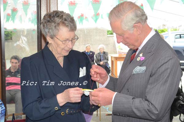 HRH The Prince of Wales placing the final stitch in an embroidered tablecloth by Llanddewi Brefi WI